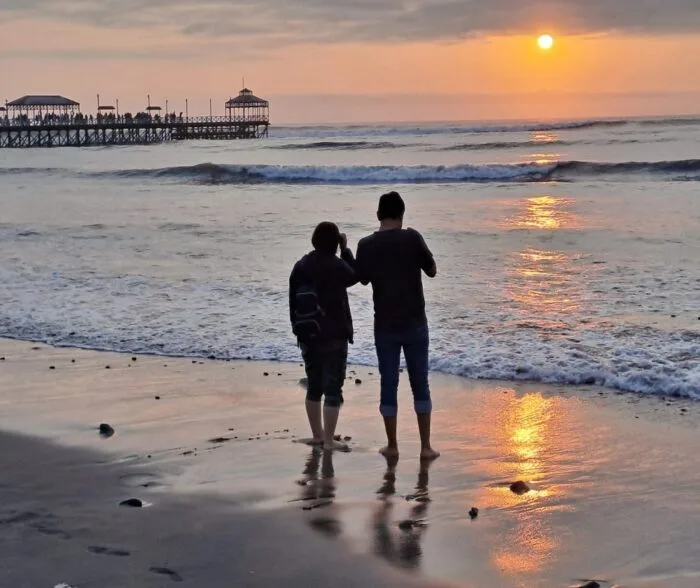 tour-trujillo-2-dias-1-noche-huanchaco Pareja disfrutando del atardecer en la playa de Huanchaco durante el tour de 2 días y 1 noche en Trujillo.