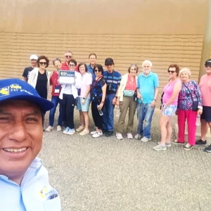 Guía de turismo de Viajes In Perú explicando la historia local a un grupo de viajeros en Trujillo